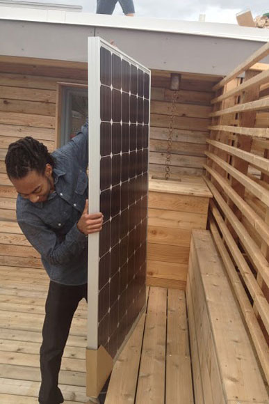 A worker installs solar panels on a home