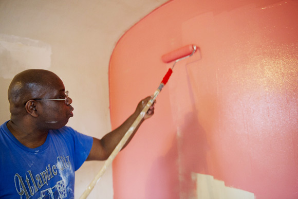 Brown paints a bedroom wall pink in a Northeast home he is helping redesign