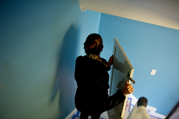 Julianne Yurek, brand manager with design/build firm Carnemark, helps carry doors from a built-in closet system out to the Community Forklift truck