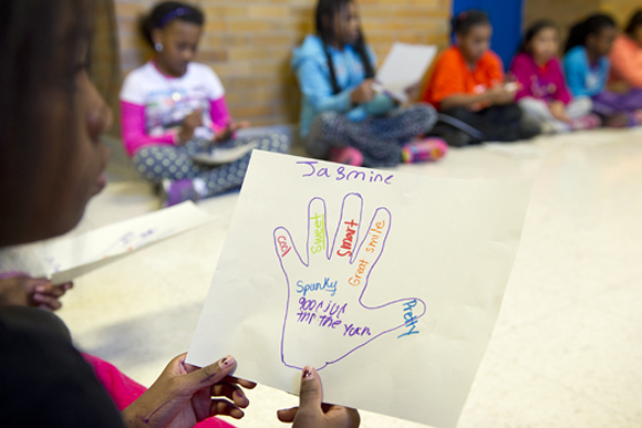 Girls look at the encouraging words their friends wrote about them during a lesson about self-image