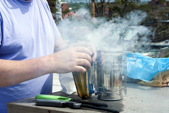 Jeff Miller prepares to smoke one of the hives he keeps on his Georgetown roof. The smoke calms the bees down