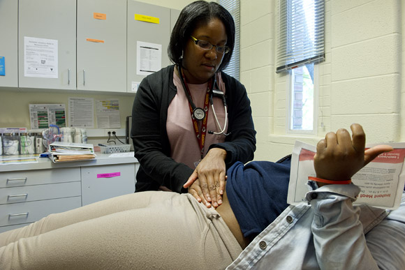 Dr. Lekeisha Terrell palpates a student's stomach during an exam at the Ballou student health center