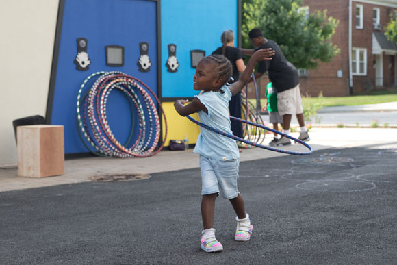 A child dances in the alley between Dance Place and the Artspace Lofts during an open house