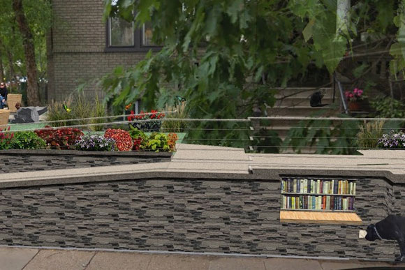 A bench serves as a place for the public to sit, a place for a free library, and a continually circulating dog bowl