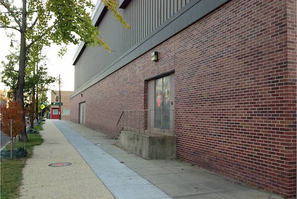 The existing wall: a blank brick facade along an otherwise booming commercial and residential corridor