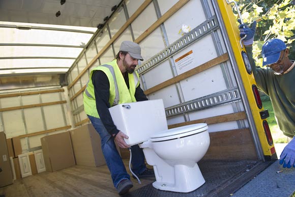 A Community Forklift staffer loads a toilet from a NW home onto the Forklift's truck
