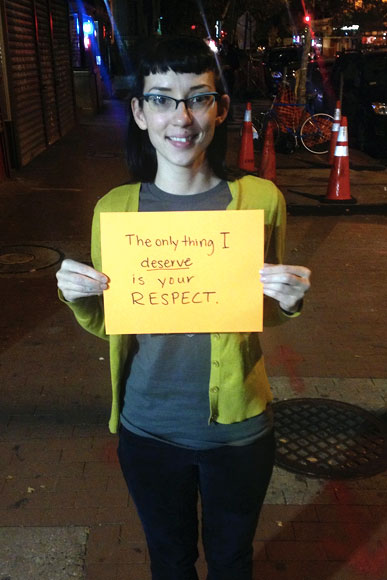A woman holds a sign asking for respect, not harassment, as part of a Collective Action for Safe Spaces anti-harassment workshop