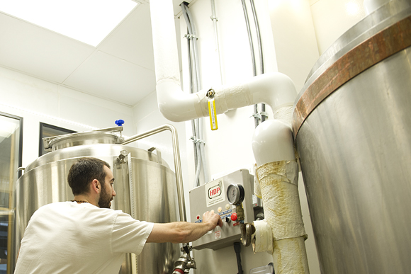 Jonathan Werth, cellerman at Right Proper, adjusts the controls in the brewing room