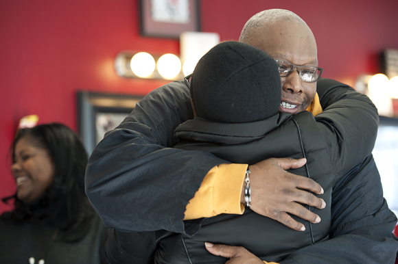 Duane Johnson, owner of M&S, hugs a customer before she leaves the shop