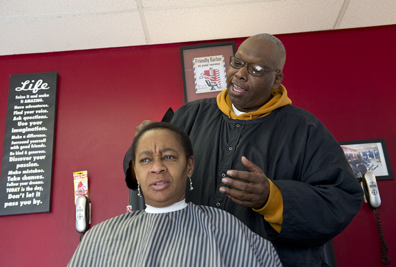 Duane Johnson, owner of M&S Barber Services, chats with customer Betty Jackson as she gets her hair cut. M&S will be moving soon as the building has been bought and will be redeveloped