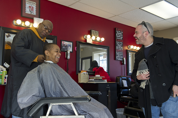 Johnson chats with local Advisory Neighborhood Commissioner Joe Barrios while cutting a customer's hair