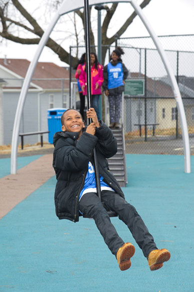 A child enjoys a ride on the zip line at Douglass playground at the grand opening