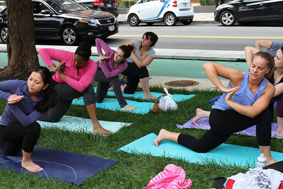 Participants in a free yoga class organized by YogaNoma, which is opening its indoor studio Oct 15